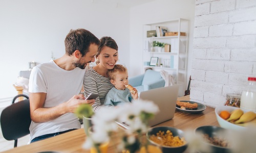 a family eating together looking at a laptop